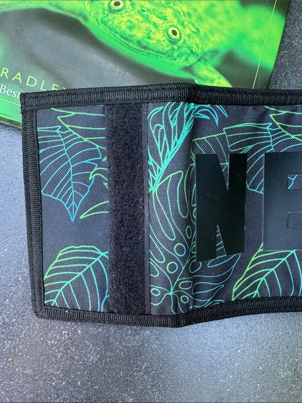 NWOT NEFF black background with tropical theme trifold wallet. Zipper pocket.